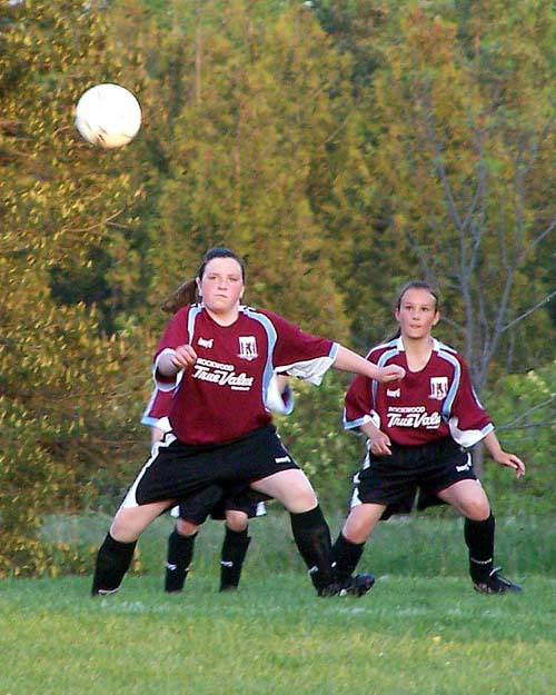 Rockwood True Value, Acton girls under 14 soccer team. The girls look at an incoming soccer ball.