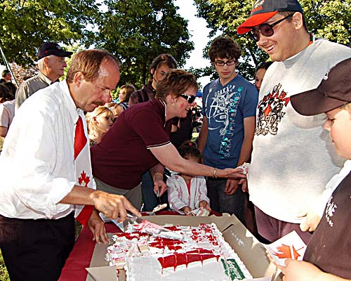 Acton's 2008 Canada Day celebrations - Mayor Rick Bonnette cuts up the birthday cake donated by Acton Sobeys