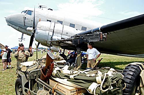 Military reenactors gather around a jeep and a Douglas aircraft at the 2008 Geneseo Airshow