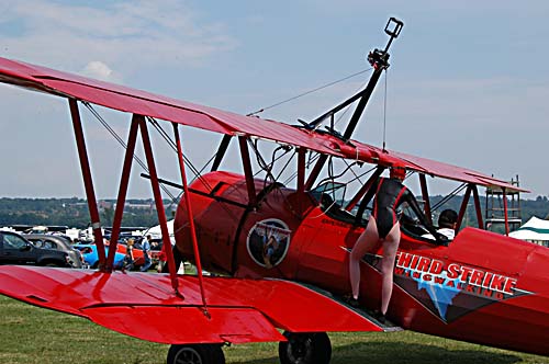 2008 Geneseo Airshow - Canadian female wing-walker Carol Pilon of Quebec - makes her way to the top of the wings on the biplane