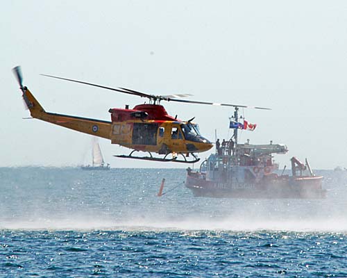 SAR helicopter passes centre stage fireboat during 2007 CNE Toronto International Airshow