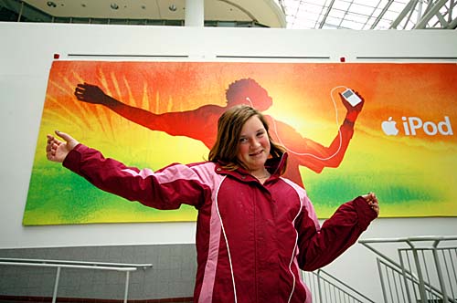 Erin poses in front of a colourful ipod ad in the Eaton Centre in Toronto, Ontario