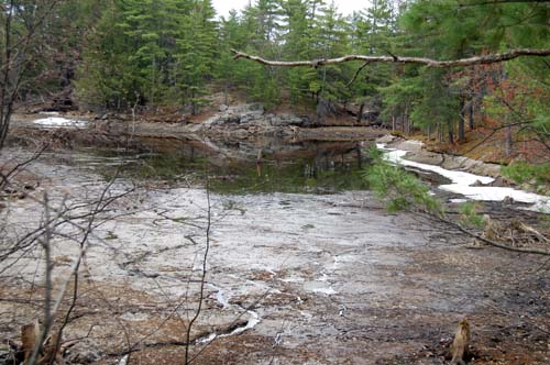 Swift Rapids Dam back bay, emptied of water to allow flow in main channel to drain spring run off