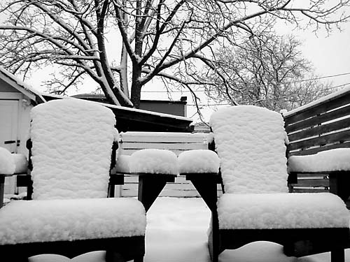 snow on adirondack chairs